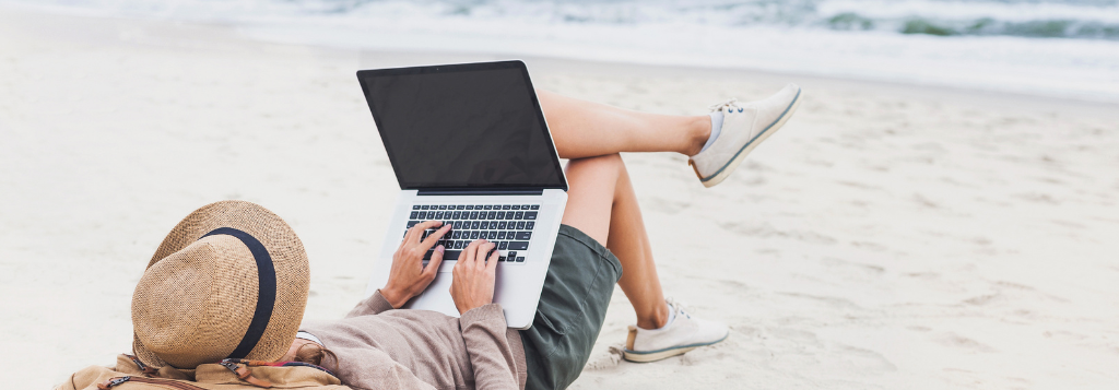 person using a laptop at the beach