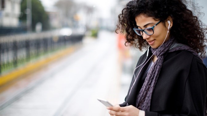 woman using headphones attached to phone